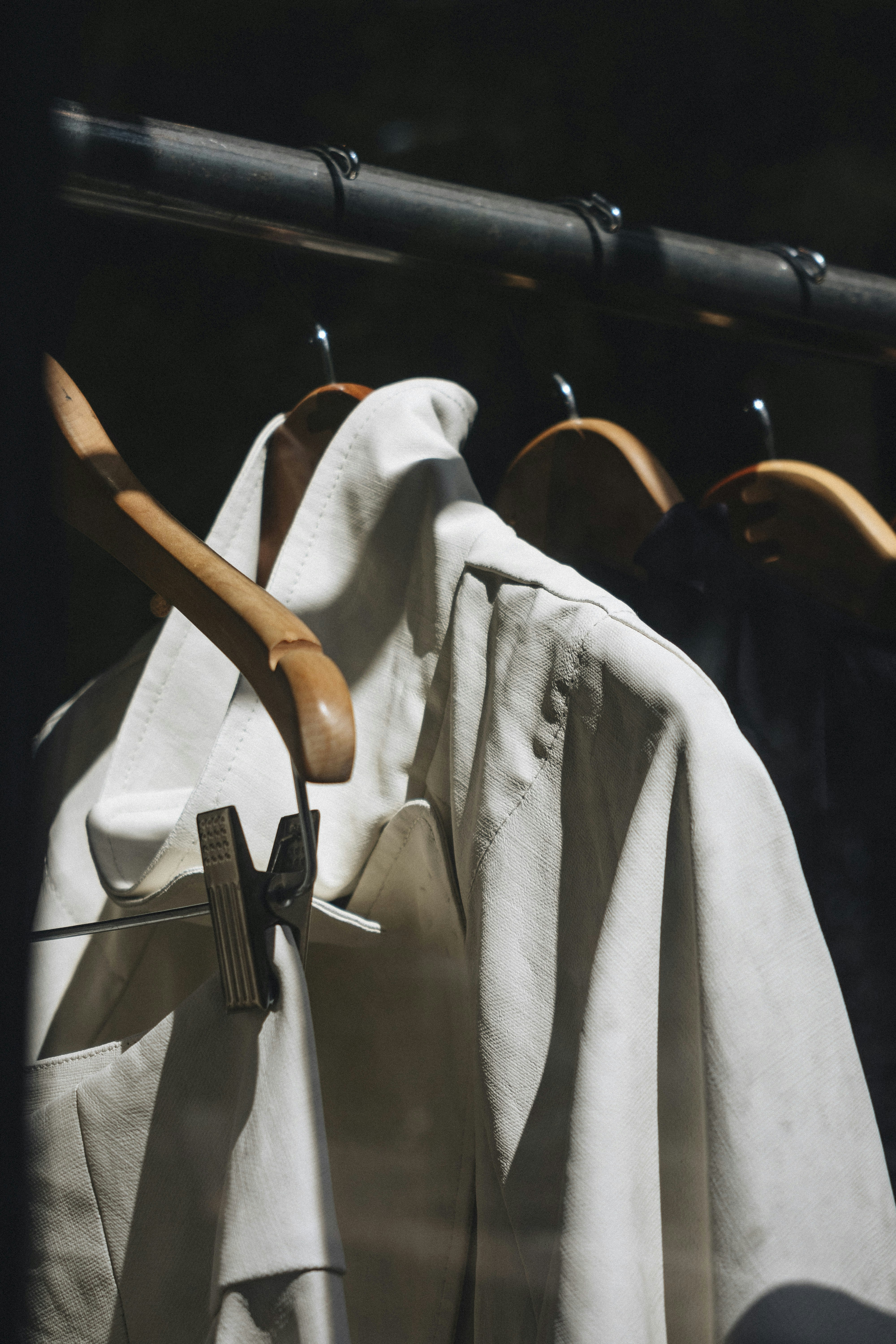 white dress shirt hanged on brown wooden clothes hanger